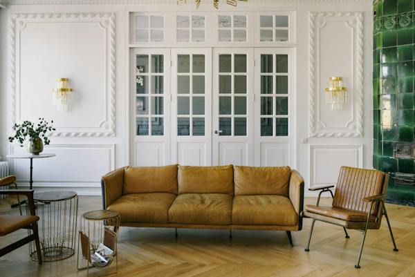 A classic white room interior with decorative moulding and brown furniture